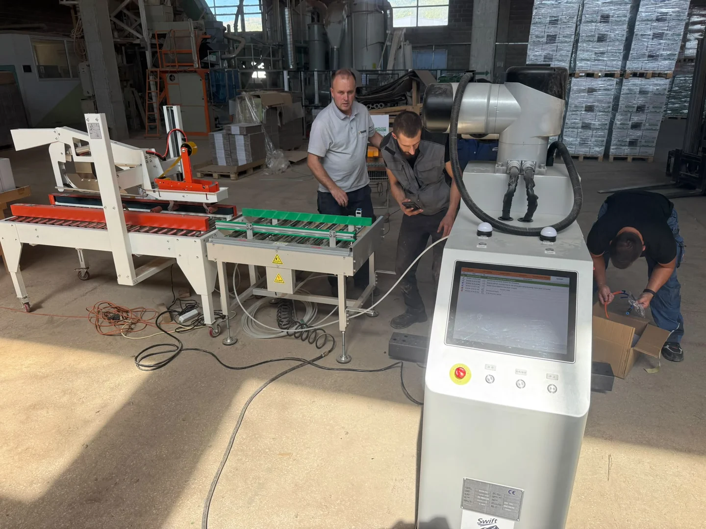 Carton sealing equipment, conveyors and a robot at a customer site
