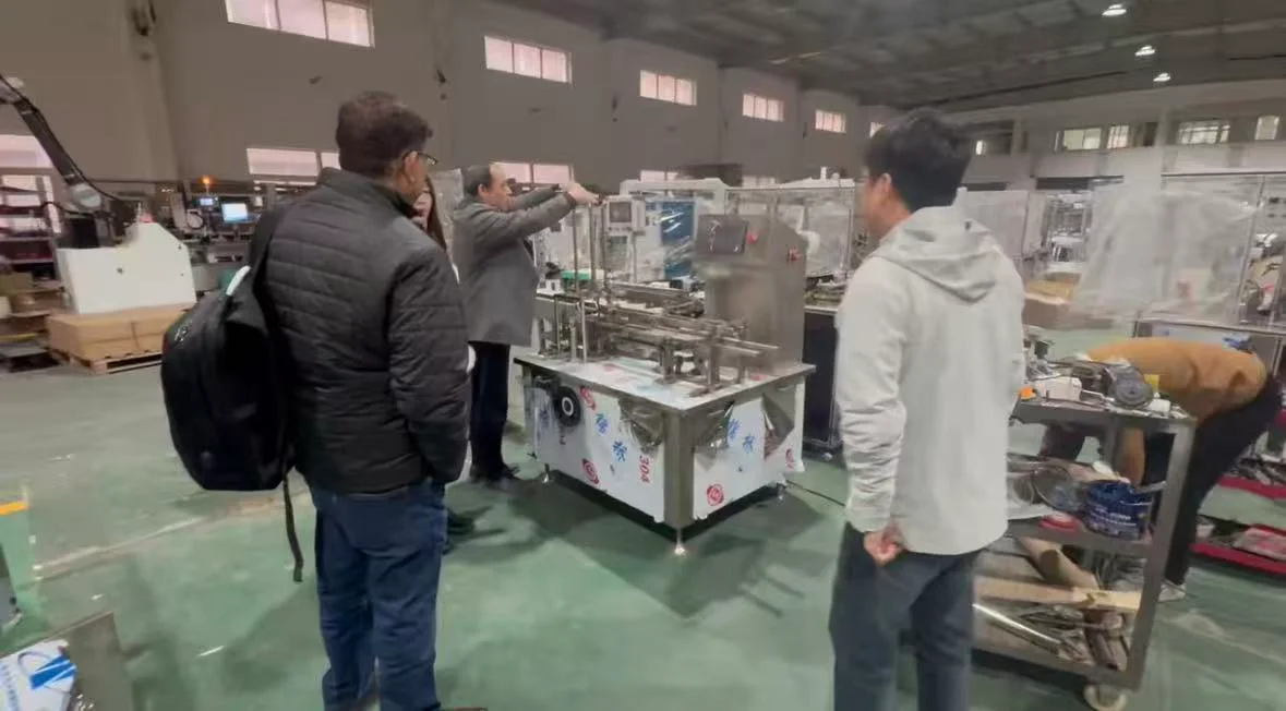 Customers and Xunding representatives beside packaging equipment during a workshop visit