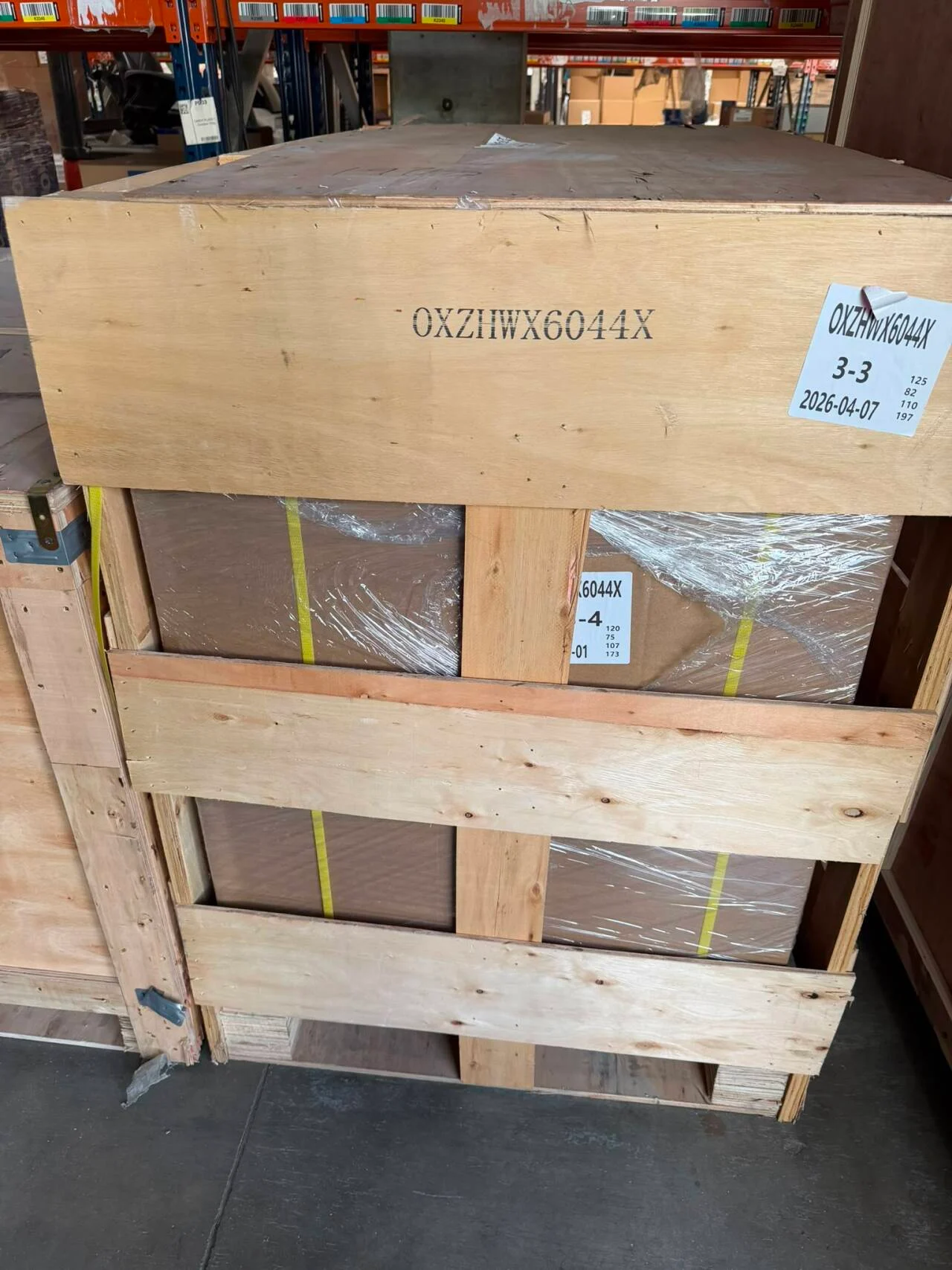 Timber-framed machinery package with protective wrapping and straps at a French customer’s factory
