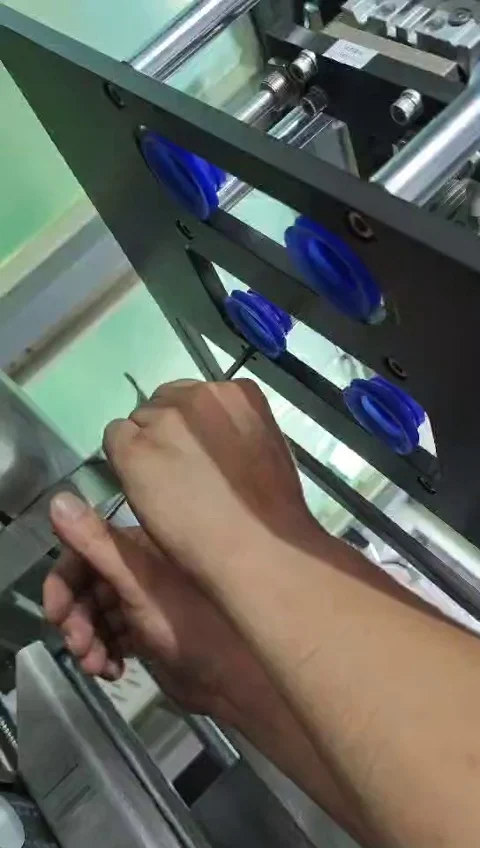 Technician using an Allen key beside the upper plate with four blue suction cups and polished guide rods