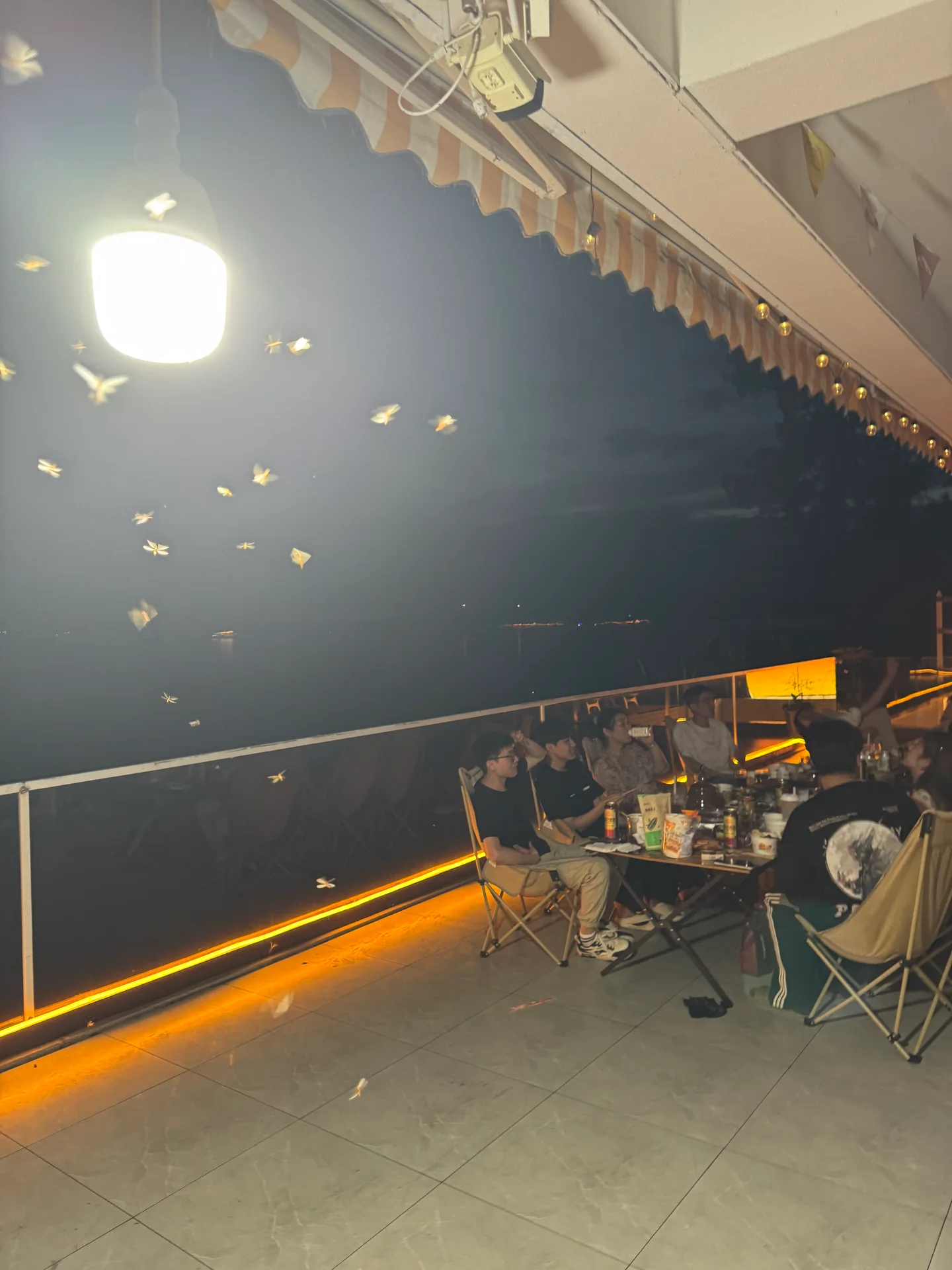 Xunding colleagues seated around a table on an outdoor terrace in the evening